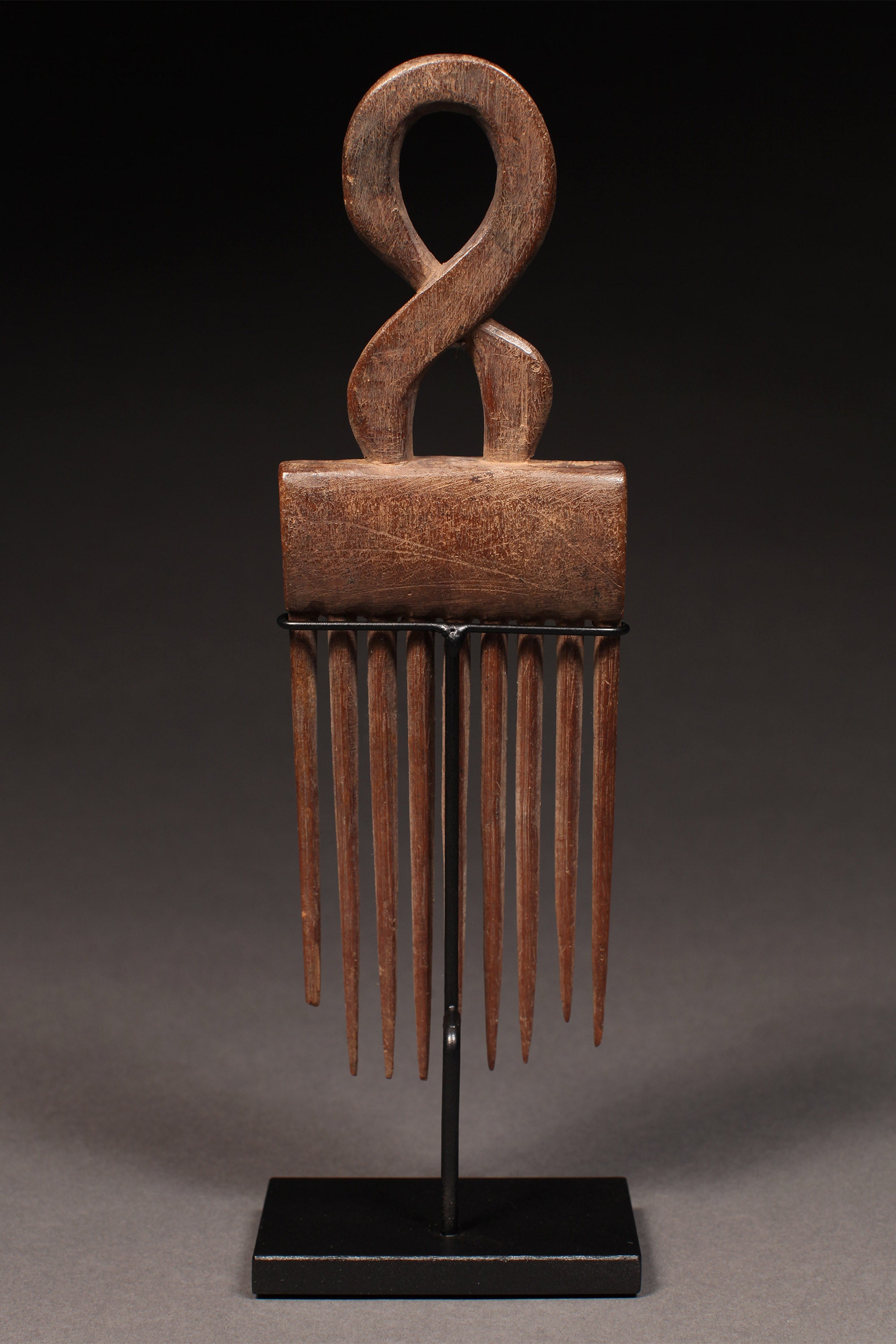 Tribal Objects - African Tribal Art - Ancient Ceremonial Art - Handcrafted Artifacts - Masks - Wood Sculptures - Iron Bronze Objects - Textiles - Art Pieces - African Folk Art - This classic comb with carved superstructure is a unique African sculpture, handmade by the Ashanti people of Ghana. It is crafted from fine wood and has a beautiful, intricate detail that makes it a true collectible.  H: 10” Inventory # 10414