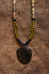 Handcrafted Necklaces - Handmade - African Art - Jewelry - Beaded Necklaces - This Tribal Beaded Jewelry Necklace is handmade from African vintage chevron trade beads, assembling a unique and exotic tribal style. Each bold pendant complements the look and feel of its wooden base, creating a timeless piece for any occasion. Length: 13" Inventory # 10852
