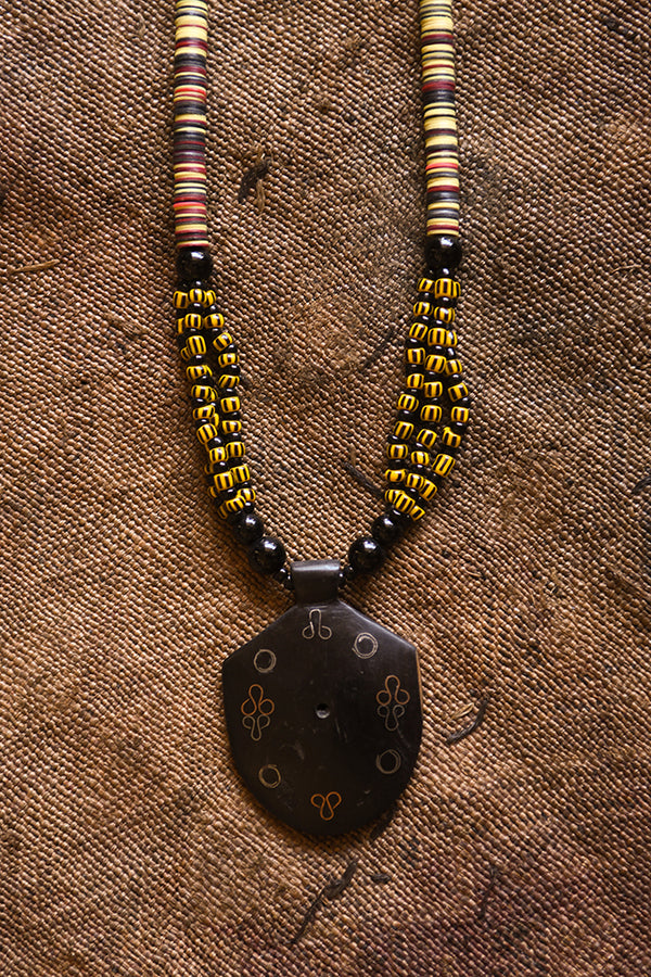 Handcrafted Necklaces - Handmade - African Art - Jewelry - Beaded Necklaces - This Tribal Beaded Jewelry Necklace is handmade from African vintage chevron trade beads, assembling a unique and exotic tribal style. Each bold pendant complements the look and feel of its wooden base, creating a timeless piece for any occasion. Length: 13" Inventory # 10852