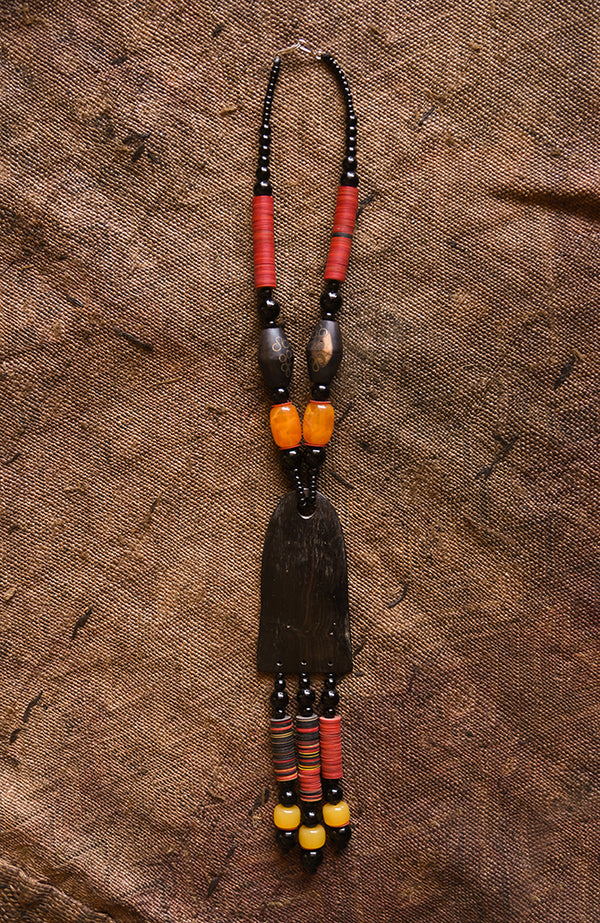 Handcrafted Necklaces - Handmade - African Art - Jewelry - Beaded Necklaces - This Tribal Beaded Necklace is the perfect combination of stylish and timeless elegance. It's handmade with Carnelian beads and African Tribal Jewelry, and features a beautiful wood pendant that adds a classic touch. Wear this necklace and make a bold statement every time.  Length: 16"  Inventory # 10857