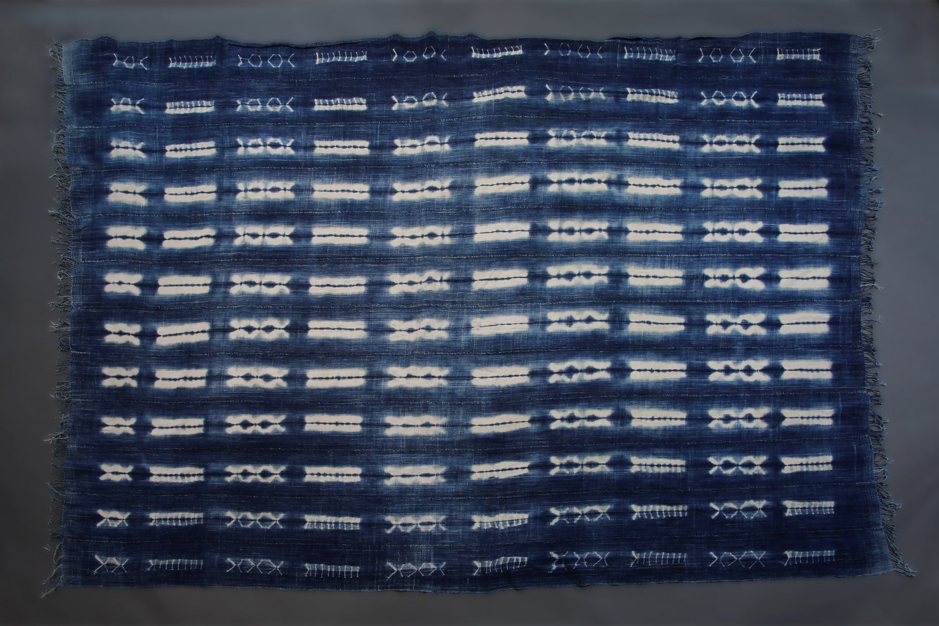 Handcrafted Textiles - Artisan Designed - Handcrafted African Art Textiles - Home Decor - Living Spaces - Mix Colors - Bold Patterns - Traditional Designs - African Culture - This Dyed Indigo Blue White Vintage Cloth is perfect for home decor projects. It's made from a high-quality African Mossi cotton fabric tie-dyed with a Shibori Indigo dye. The blue and white pattern creates a stunning effect that will elevate any space. 74 