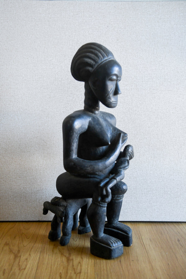 Tribal Sculptures - Home Decor - African Art - Ancestral - Statues Figures - Crafted - Centuries - Old Techniques - Sculptures Cultural - African Heritage - Living Space - African Tradition - Home - Office - This Ashanti Seated Maternity Figure is an exquisite carving crafted with traditional African sculpture techniques. Carved from wood, the figure celebrates the beauty of parenthood with its detailed workmanship and timeless design. Collectors will admire its graceful curves and rich colors.