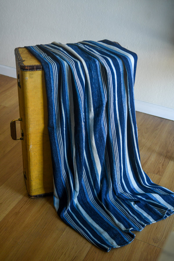 Handcrafted Textiles - Artisan Designed - Handcrafted African Art Textiles - Home Decor - Living Spaces - Mix Colors - Bold Patterns - Traditional Designs - African Culture - This Striped Textile is constructed from Vintage African Cotton material and is distinguished by its Indigo Dyed design. As a home decor accent, it adds a sophisticated yet bold touch to any living space. Length: 62 inches Width: 43 inches