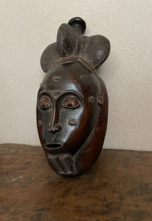 Handcrafted Masks - Artisan Designed - African Art Masks - Handcrafted Traditional - Home Decor - Business - Mask - Artwork - Any Space - African Art Mask - This Decorative Baule Mask is hand-carved from wood and makes a unique wall decor piece. With its vintage styling and timeless African art form, it adds a one-of-a-kind character to any room. Add some class to your home and bring the culture of a bygone era to the present. Length: 16 Inches Width: 7.5 Inches